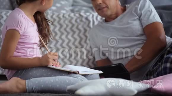 可爱的小女孩和她父亲一起画画和休息