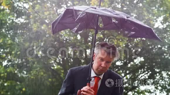 在雨中躲在破雨伞下的白人商人视频