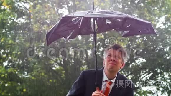 在雨中躲在破雨伞下的白人商人视频