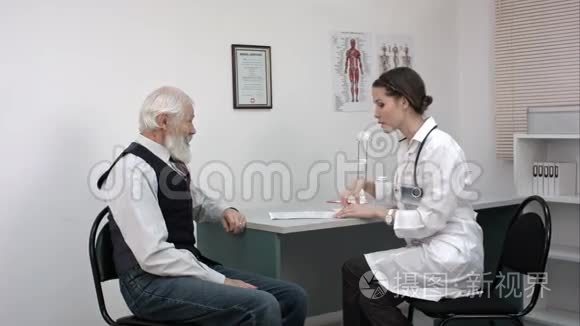 医生和她的男性老年病人谈话并写了些东西。