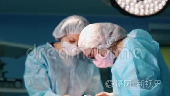 在手术室，两个外科医生在手术中。 现代医院的专业医生。 整形外科手术