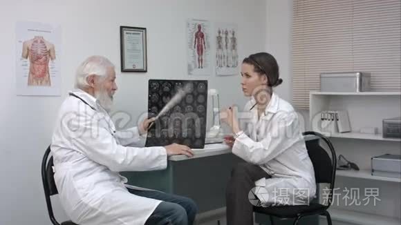 高级医生检查人头的MRI图像。 高级男性医生教年轻女性医生。
