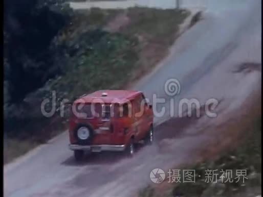 警车在乡间道路上追逐红色货车的高角度视角