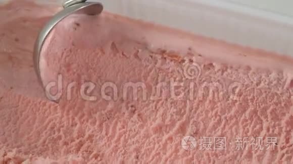 草莓冰淇淋用勺子舀出容器