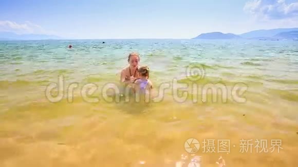 小女孩跟着妈妈的舞会来到沙滩视频