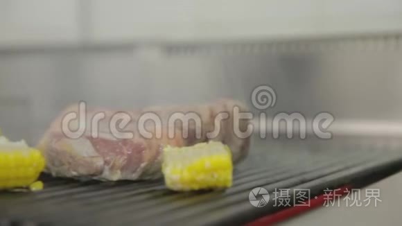 牛排烹饪。牛排放在红桌子上，厨师在餐馆里加调味料