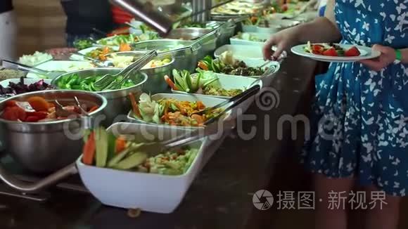 女人在饭店的自助餐盘上放食物视频