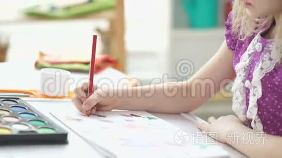 绘画。 八岁的女孩坐在书桌前画画