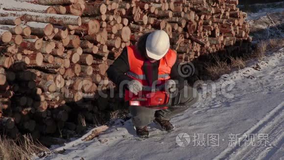 伐木工人在原木附近检查电锯视频