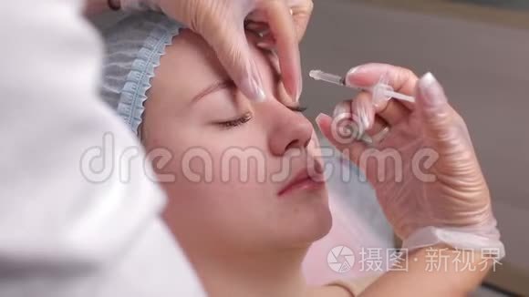 医生在中年妇女前额眉间注射面部提升注射以消除面部皱纹。