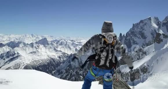 登山者在阳光明媚的一天到达雪山顶峰。 登山滑雪活动.. 冬季滑雪者