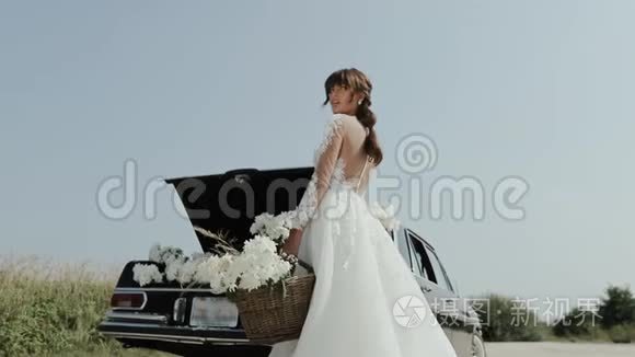 年轻美丽的女人穿着婚纱，在古董车附近拍照。