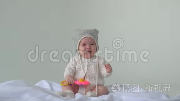 快乐的宝贝女儿。 戴帽子的孩子躺在床上笑。 白色背景。