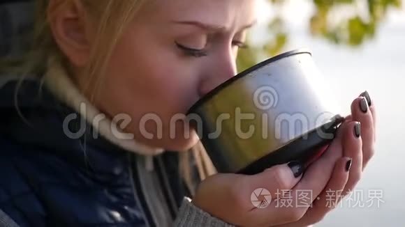 金发女郎正在喝热水瓶里的茶视频