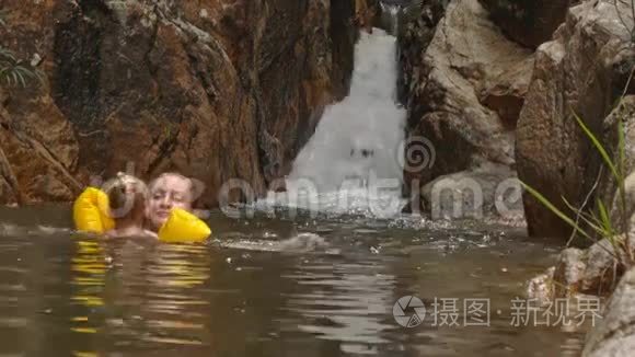 小金发女孩在瀑布边游泳