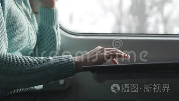 年轻女孩坐火车，用笔记本。 女性手使用笔记本电脑的触摸板。 女孩在聊天