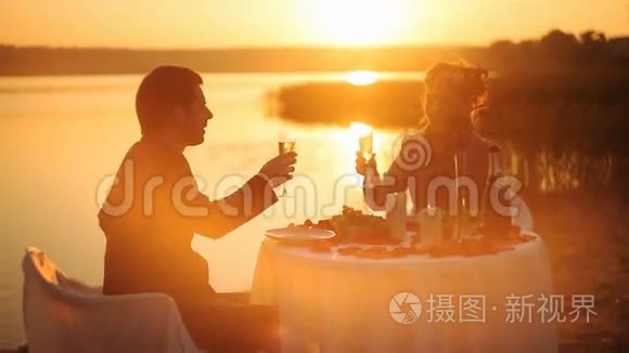 年轻夫妇在海滩上共享浪漫晚餐视频