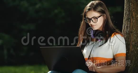 在公园里用笔记本电脑工作的女人