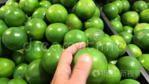 男子手在农民超市选择绿色有机曼达林。