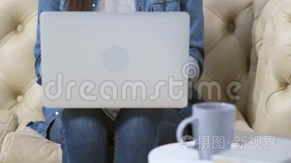 活泼开朗的年轻女人在沙发上用笔记本电脑