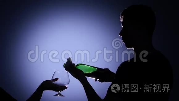 服务员给女孩倒了一杯红酒。 背光灯