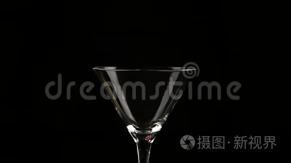 粉红色的鸡尾酒在黑暗的背景上倒入一杯。 慢动作