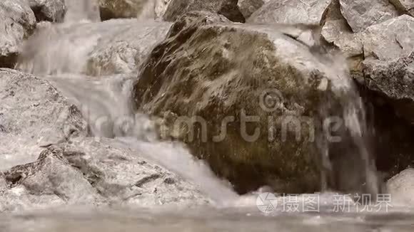 水流缓慢地在石头上落下，溪流在石头上落下，溅起，小山