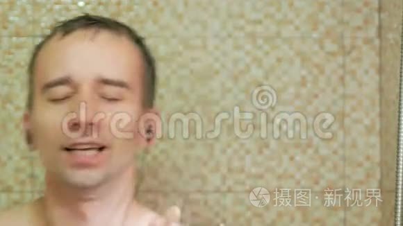 一个男人在酒店洗澡，用耳机听音乐。 他大声唱歌，喜欢洗衣服