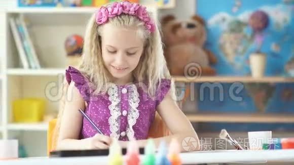 漂亮的女孩用彩色铅笔仔细画画。