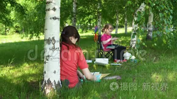 妈妈和女儿在树荫下的公园里从事创造力。