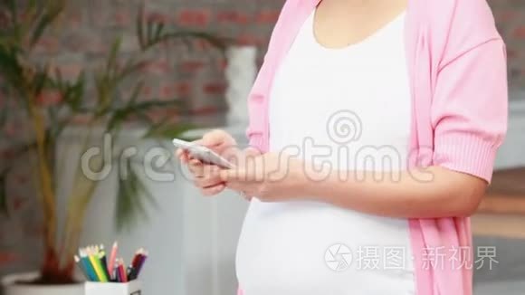 怀孕的亚洲女人用她的手机