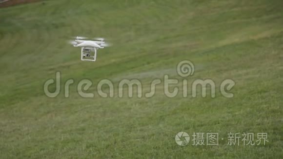 白色无人机四架飞机在草地背景下的蓝天上飞行