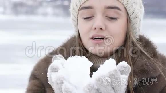 美丽的快乐女孩在户外吹雪。 慢慢地