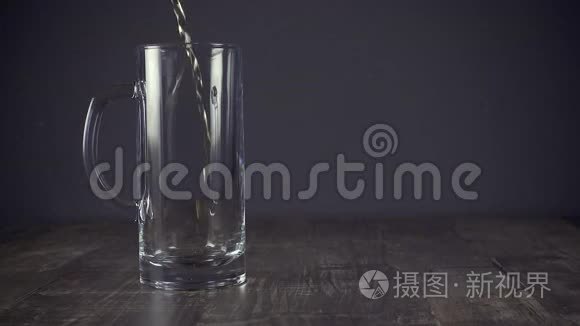 慢动作把淡啤酒倒在灰色背景的杯子里