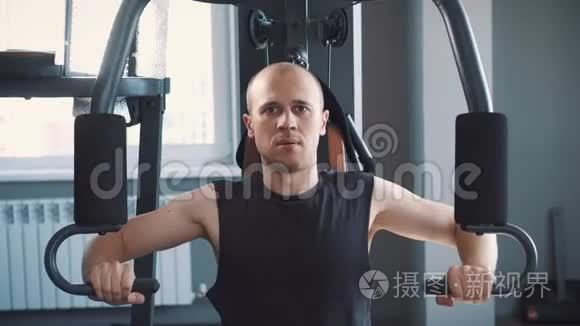 健身室的年轻肌肉男练划艇机视频
