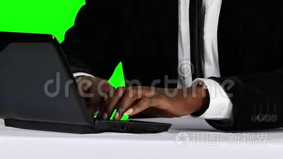 年轻的商人在他的办公桌上用笔记本电脑工作。 绿色屏幕