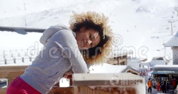 滑雪场上靠在栏杆上的微笑女人