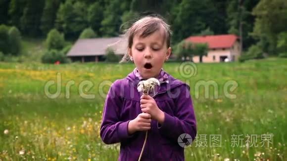 小女孩吹蒲公英的花朵