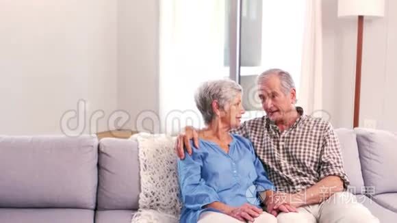 可爱的成熟夫妇在沙发上聊天