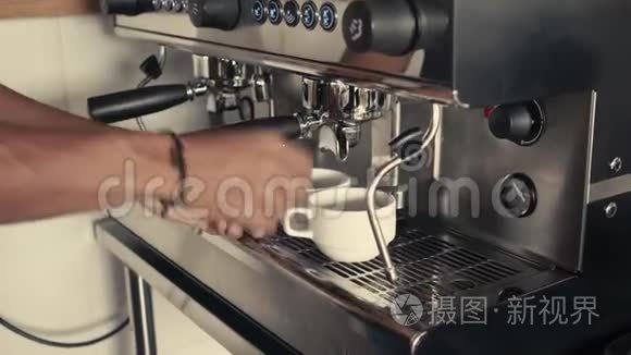 咖啡师在工业浓缩咖啡机上用不锈钢不倒翁制作美式或卡布奇诺。 特写镜头。 概念