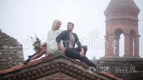 一对夫妇坐在老楼的屋顶上视频