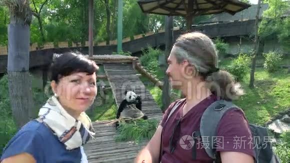 两个快乐的人在动物园里看熊猫视频