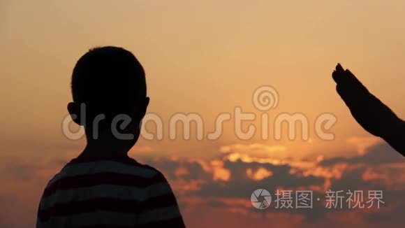 在夕阳下，太阳在黎明时牵着母亲的手，剪影