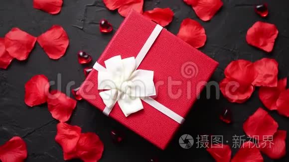 黑石桌上的礼盒.. 带有玫瑰花瓣的浪漫节日背景
