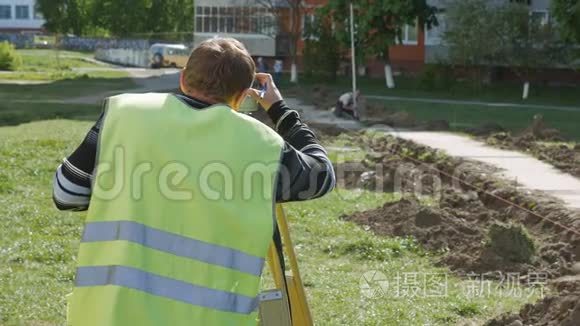 道路修复中的特种设备工作.. 测量员在测量道路上的距离时