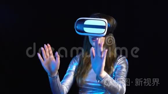 戴着虚拟现实谷歌的银色服装的网络年轻女子