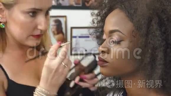 美黑人美女模特化妆师工作时的特写。 漂亮的黑人女士