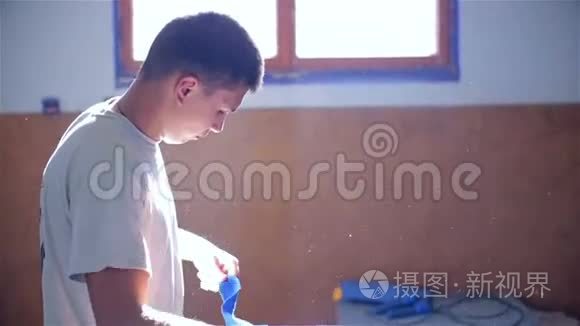 一名男子将一名年轻的拳击手绑在手上