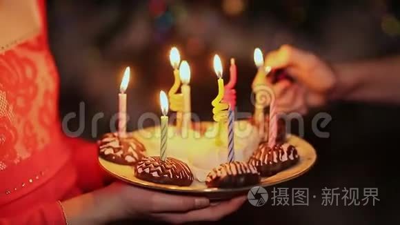 两个十几岁的女孩在生日时点燃蜡烛。 带蜡烛的蛋糕