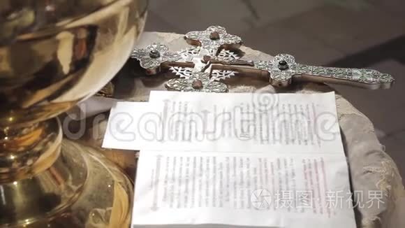 教堂圣经旁边祭坛上的银正体十字架。 桌子上的谎言特写